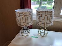 Pair of retro-style table lamps on a white table with window background, showing overall front and side views.