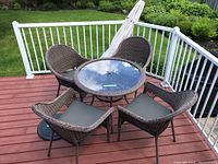 Full overview of table, chairs, umbrella and base on deck