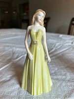 Front view of Royal Doulton Capricorn figurine showing woman in yellow gown.