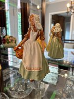 Front and side view of Royal Doulton The Milkmaid figurine showing detailed traditional dress and milk pail.
