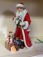 Front view of the Royal Doulton Father Christmas figure with gifts and teddy bear at feet.