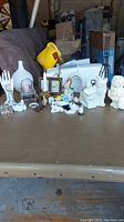 Full view of all items on table showing variety including figurines, candle holders, bell, and music box.