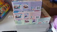 Stack of three sealed Playskool learning game boxes showing back labels and product information.