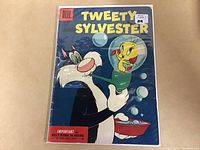 Front cover of 1955 Tweety & Sylvester #10 comic book inside protective plastic. Shows Sylvester the cat and Tweety in a fishbowl on blue background with bubbles.