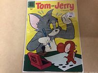 Front cover of 1956 Tom and Jerry comic book issue #139 in protective plastic sleeve showing the characters and cover details under light reflections.
