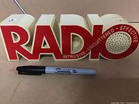 Front view of the vintage radio shaped 'RADIO' with a Sharpie marker shown for scale.