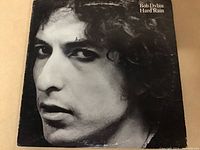 Front cover of Bob Dylan Hard Rain vinyl LP record showing a black and white close-up of Bob Dylan's face.