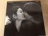 Front cover of the John Lennon and Yoko Ono 'Double Fantasy' vinyl record album featuring a black and white photo of the artists kissing.