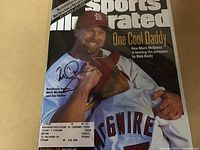 Front cover of Sports Illustrated magazine showing Mark McGwire with a hand signature in black ink.