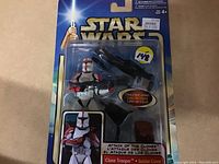 Front view of unopened Star Wars Clone Trooper figure on card showing figure with firing tripod cannon and branding.