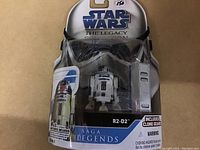 Full view of the packaged R2-D2 figure showing the card and blister packaging, brand title, and accessory included.