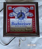 Front view of the Budweiser lighted clock showing the illuminated face with clock hands at 8:00 and the horse-drawn carriage figurine at the bottom.