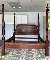 Full front view showing four carved poster posts, headboard and footboard