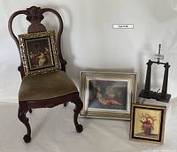 Chair with claw and ball feet and olive green horsehair cushion alongside three framed paintings for scale and display.