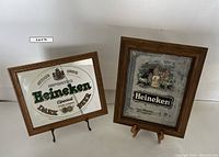 Two framed Heineken beer mirrors side by side on stands
