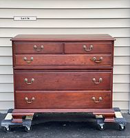 Front view of the vintage cherry wood dresser with Mt. Vernon finish and brass-colored drawer pulls.