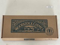 Closed cardboard box labeled Woodstock Chimes with logo and musical tuning badge
