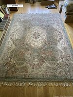 Full view of the rectangular wool area rug showing overall condition and soft muted colors.