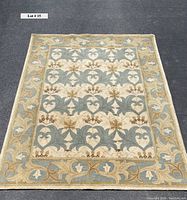 Full view of wool rug showing floral and leaf patterns and border design