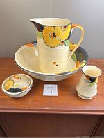 Full view of 4-piece Art Deco Myott wash basin and toilet set with floral decoration, showing jug, basin, powder jar with lid, and toothbrush holder on wooden surface.