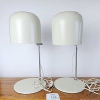 Front view of both lamps unlit showing domed shades and circular off-white bases