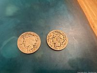 Two Peace Silver Dollars, 1922 and 1926, shown from the obverse side on a dark surface.