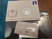 Front view of the philatelic-numismatic cover showing the silver medallion, 1977 crown emblem, and 25 cent Queen Elizabeth II postage stamp with Ottawa postmark. Certificate of authenticity visible below.