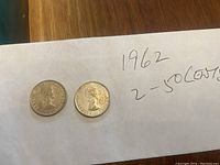 Two 1962 Canadian 50 cent silver coins on a white textured paper, showing obverse side with Queen Elizabeth II's profile.
