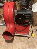 Red air blower showing curved outlet and black motor unit marked 220V with start/stop buttons.