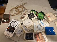 Photo showing many coiled guitar strings and multiple string packages from Martin, D'Addario, and others.