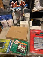 Photo showing Bamboo box on table among other boxed electronic and game items, with Crash Bandicoot standee visible behind