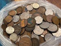 Plastic bag containing a mix of brown and silver-toned coins