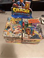 Photo showing stacks of vintage Marvel comic books including Avengers and Ghost Rider series, arranged in two piles.