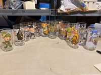 Full view of all 13 glasses arranged in a row showing all character designs clearly.