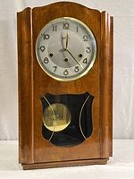 Full front view of wooden case clock with glass door closed