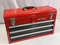 Front view of red Craftsman tool box with three drawers and top tray.