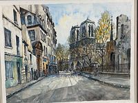 Close-up photo of the watercolor print showing Paris street scene with Notre Dame Cathedral and artist signature.