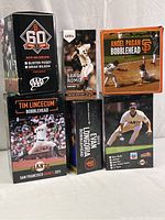 Photo showing the group of six San Francisco Giants bobbleheads in original boxes, including Brian Wilson, Sergio Romo, Angel Paganini, Tim Lincecum, Evan Longoria, Jeff Kent.