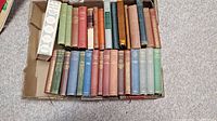Box of 32 antique hardcover books in various colors with visible age wear.