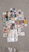 Full spread of over 150 Artists Trading Cards arranged on carpet, showing the variety and number of cards.