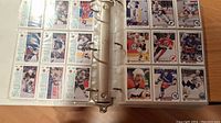 Two pages of the hockey card binder with multiple cards per page showing various players in different team uniforms from early 1990s NHL seasons.