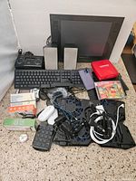 Photo of lot displaying Wacom tablets, keyboard, keypad, speaker, iPod dock, smartphone, cables, and multiple electronic items on floor