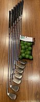 Photo of all seven left-handed Callaway golf clubs lined up with golf practice balls in mesh bag