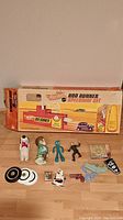 Full lot with Hot Wheels Speedway set box and assorted vintage toys and game pieces including Gumby, Snoopy doll, figurines, toy pistol, scissors and hockey nets.