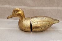 Side view of brass duck bookend halves showing one complete duck when placed together.