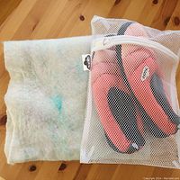 Photo of hand felted alpaca wool scarf next to mesh bag containing slippers.