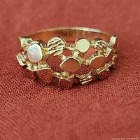 Front view of vintage gold nugget ring on textured fabric background showing gold nugget design