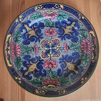 Top-down photo showing the intricate Islamic pattern with multi-colored floral and geometric designs on the plate face.