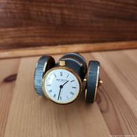 View of the watch face integrated in the small cannon model, showing the dial with Roman numerals and 'Hedy Watch' branding