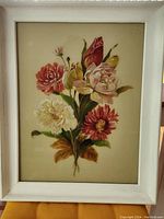 Frontal photo showing the framed vintage glass floral painting with vibrant colors in the flowers and a cream background.